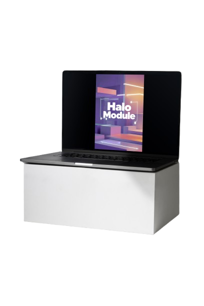 A silver and black laptop sits open on a white desk against a solid black background. The screen displays the text 'Halo Module' over a colorful graphic.